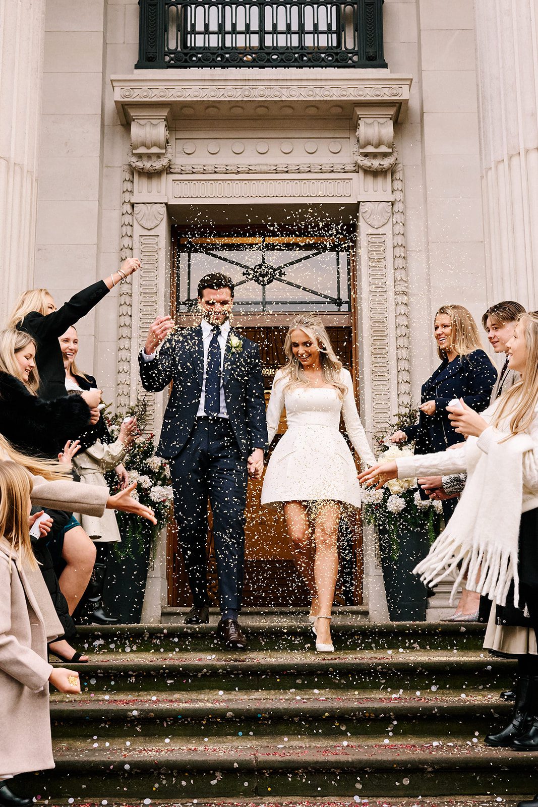 Guests showering confetti over newlyweds outside their London micro wedding venue