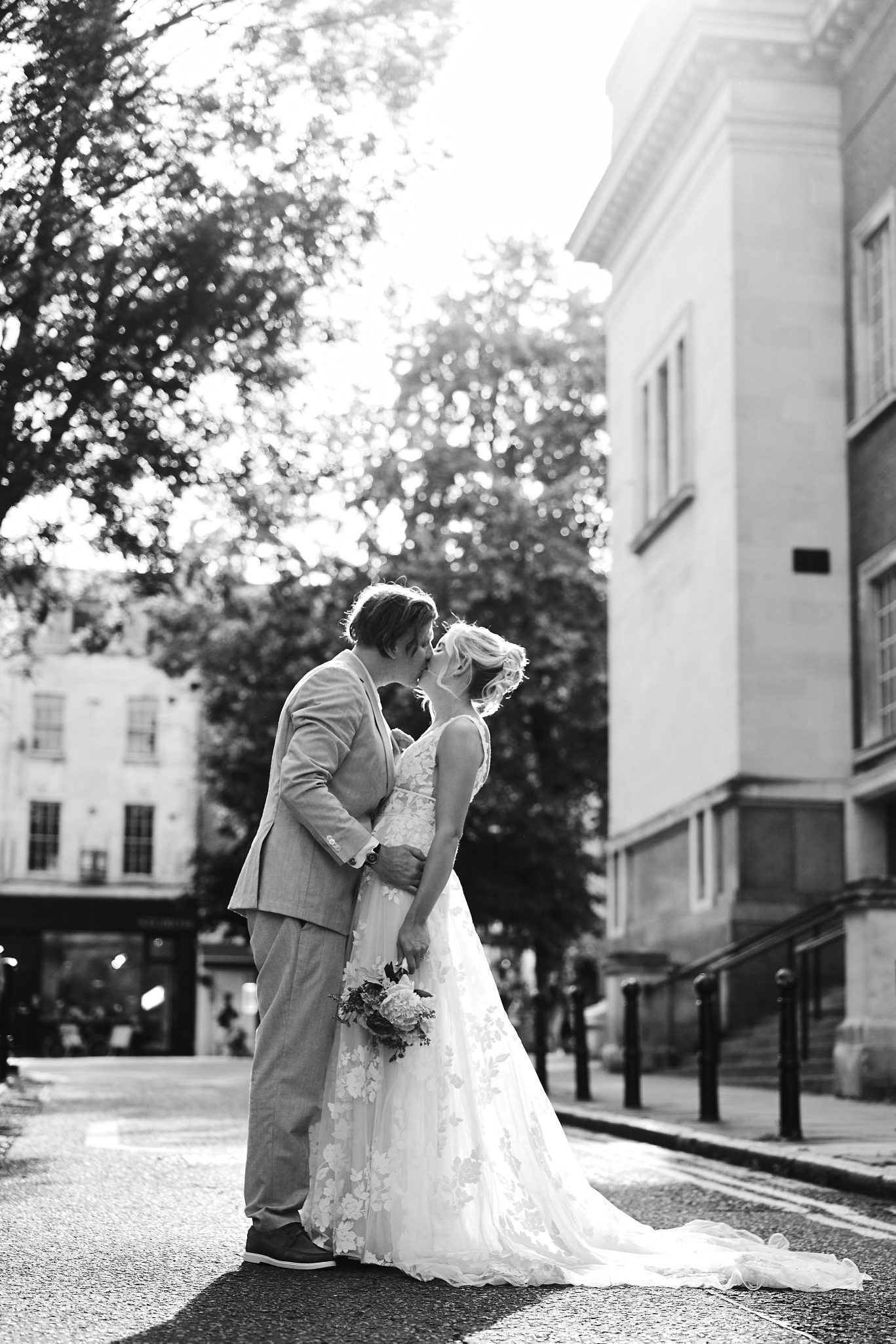 Bride and groom sharing a kiss on a sunlit London street